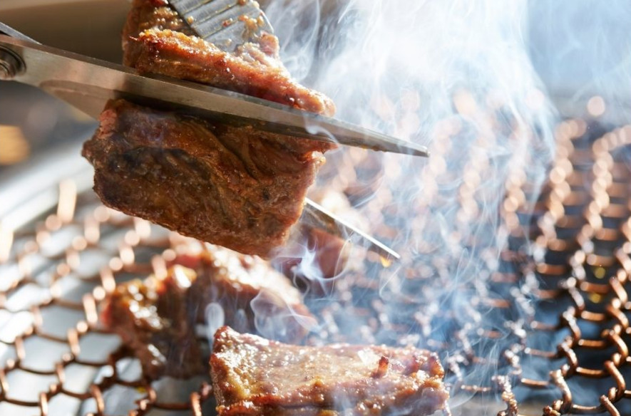 Klipper kjøtt med saks over grillen